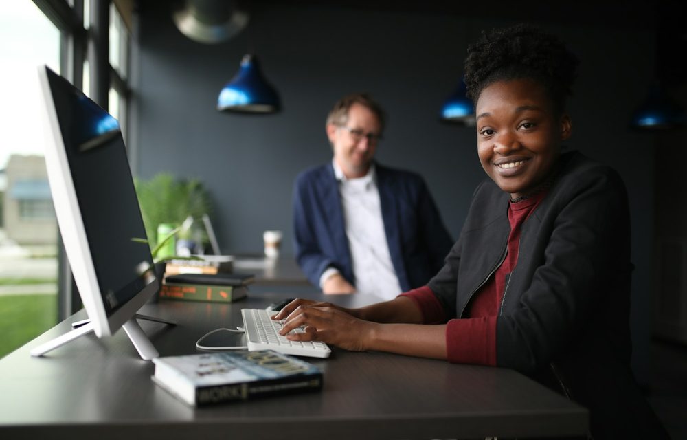 Duas pessoas comemorando um resultado na frente do computador